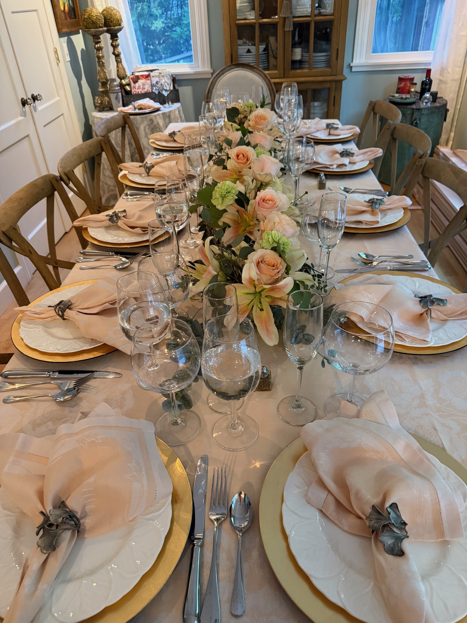 Long dinner table with peach florals and gold chargers