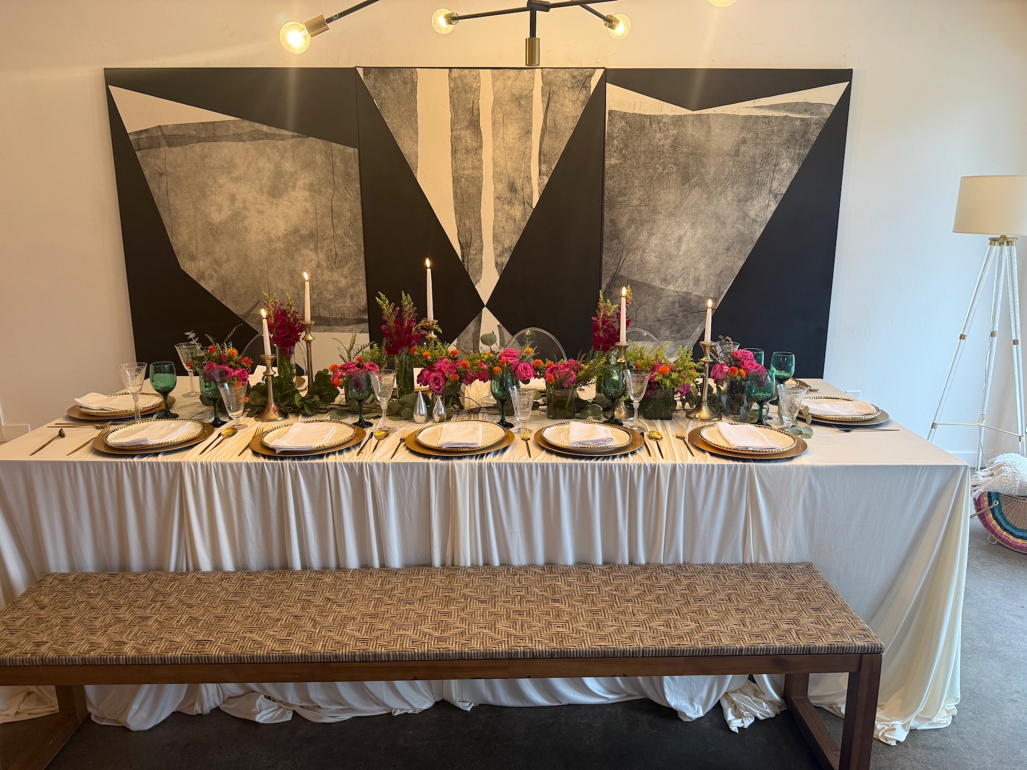 Long styled table with bold florals, candles and graphic black-and-white art backdrop