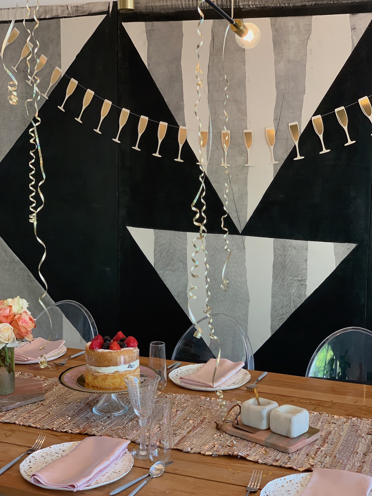 Celebration table with berry cake, blush napkins and champagne garland